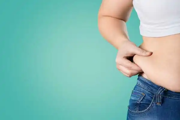 Image of woman pinching her love handles to show weight gain Small Heath